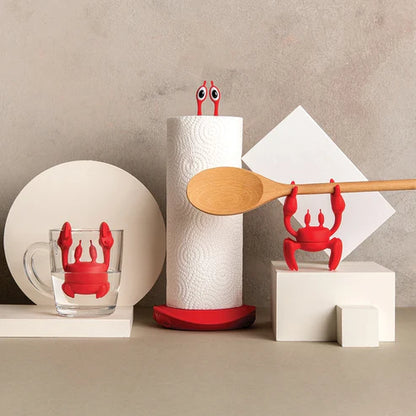 Red crab-shaped kitchen tools on a neutral background