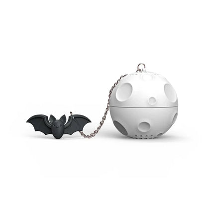 Black bat-shaped tea infuser and white spherical tea ball on a white background