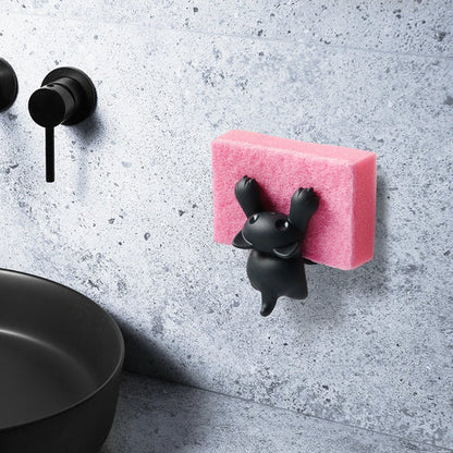 Pink sponge with black holder attached to a gray wall